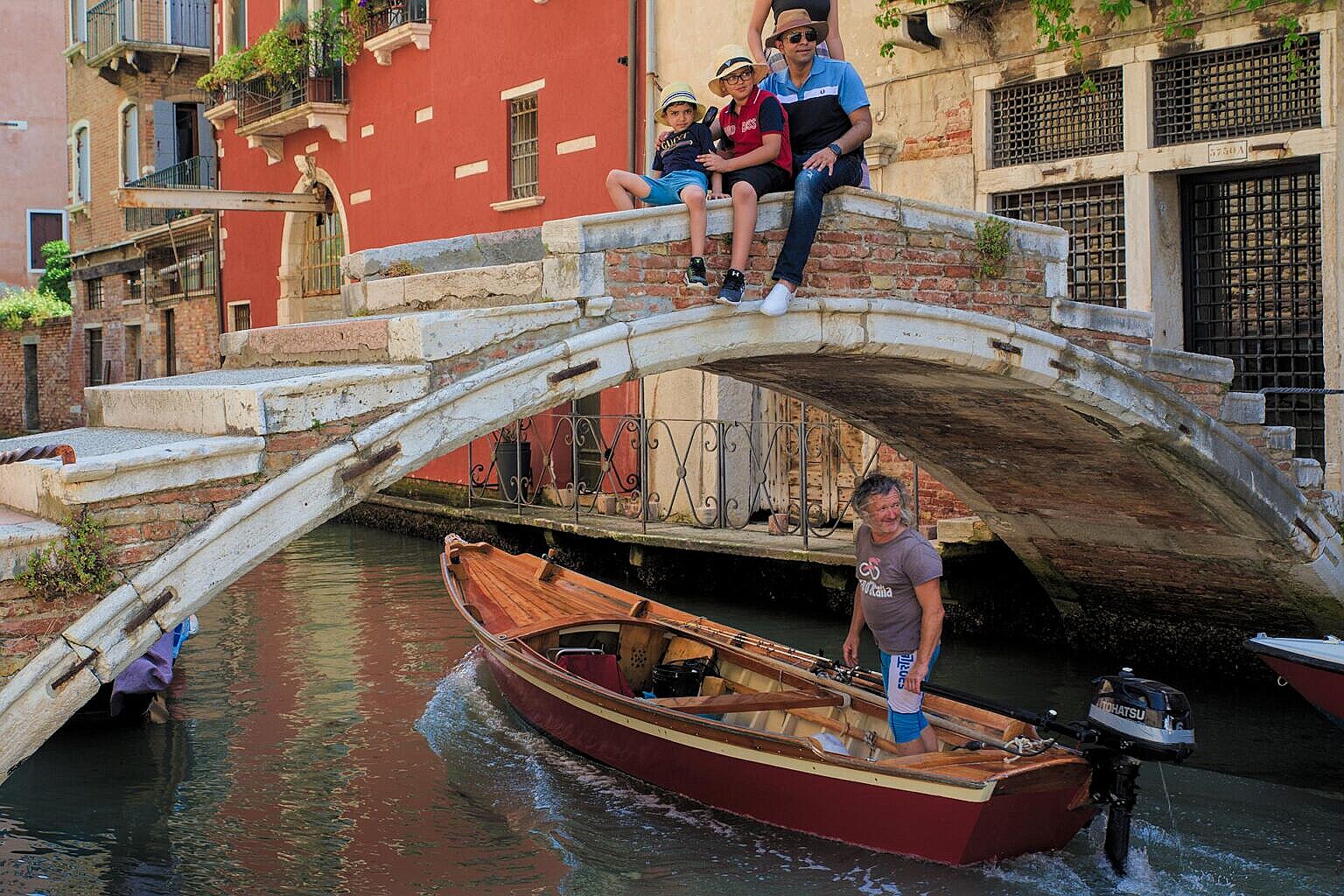 A traditional Sanpierota passing under a bridge in Venice